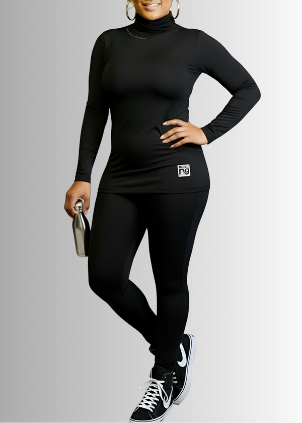 Woman wearing a black turtleneck and leggings with a visible brand logo on a gray background