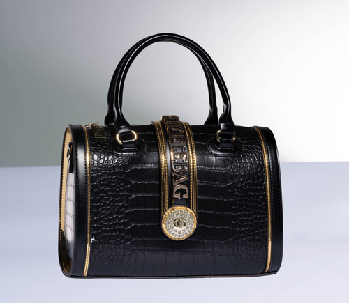 Black handbag with gold accents on a gray background
