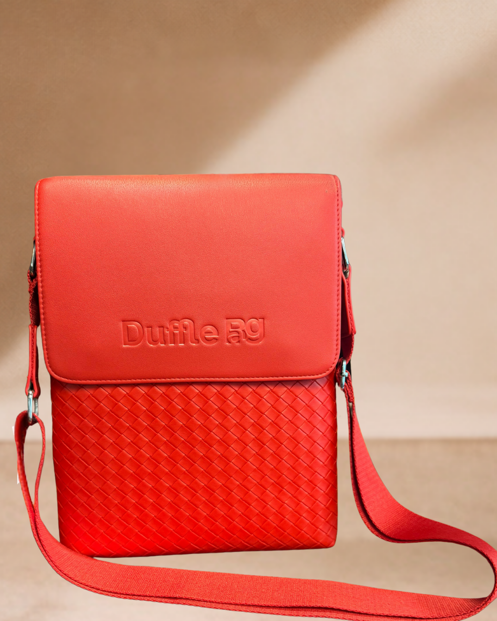 Red crossbody bag with 'Duffle Bag branding on a beige background