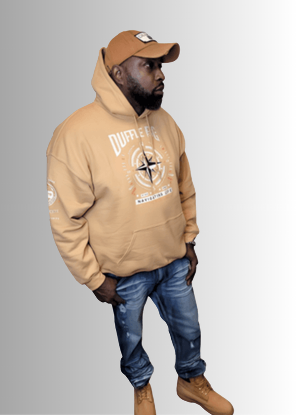 N.A.V Empowerment Hoodie by Duffle Bag showcased by a model wearing jeans and boots.
#Tan