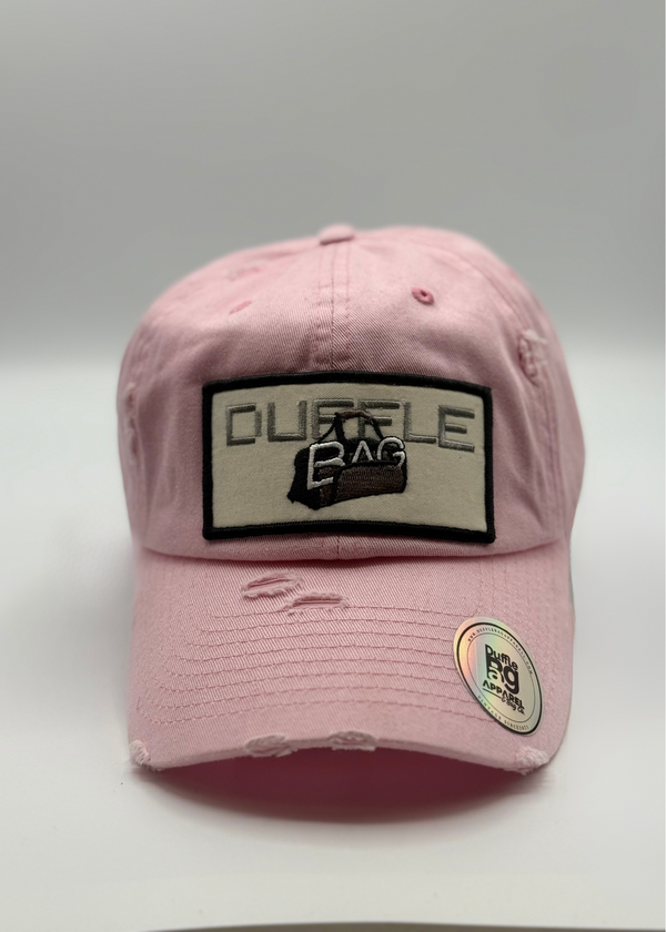 Distressed Ed Hat in pink with Duffle Bag logo, breathable mesh back, and torn visor for a stylish, laid-back look. #pink