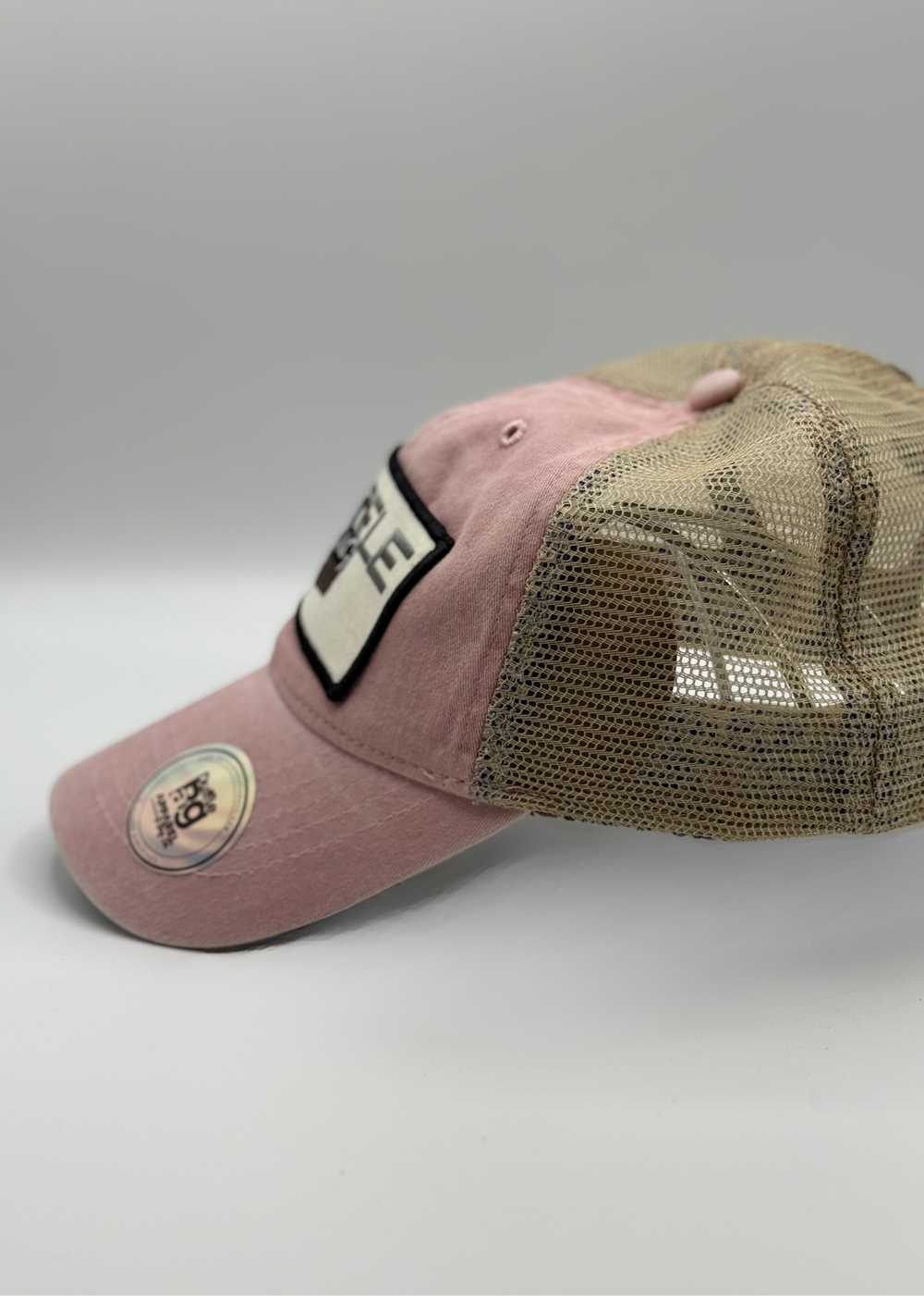 Pink Petal Trucker Hat with Duffle Bag logo, blush pink front, tan mesh back, floral print underbrim.