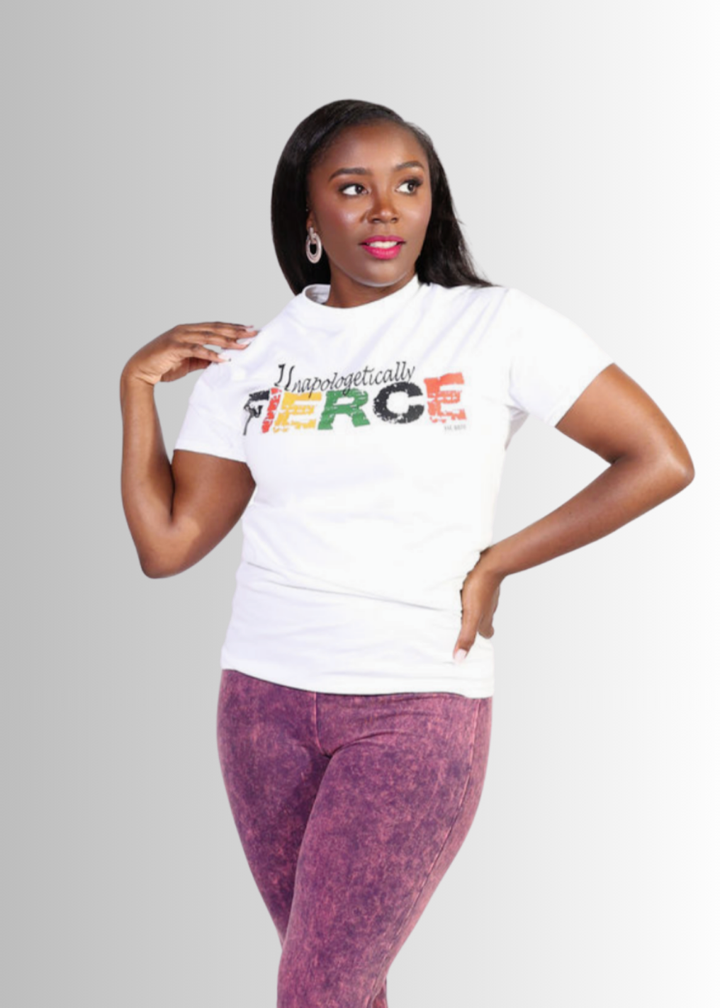 Woman wearing a white t-shirt with colorful text and purple pants on a light gray background