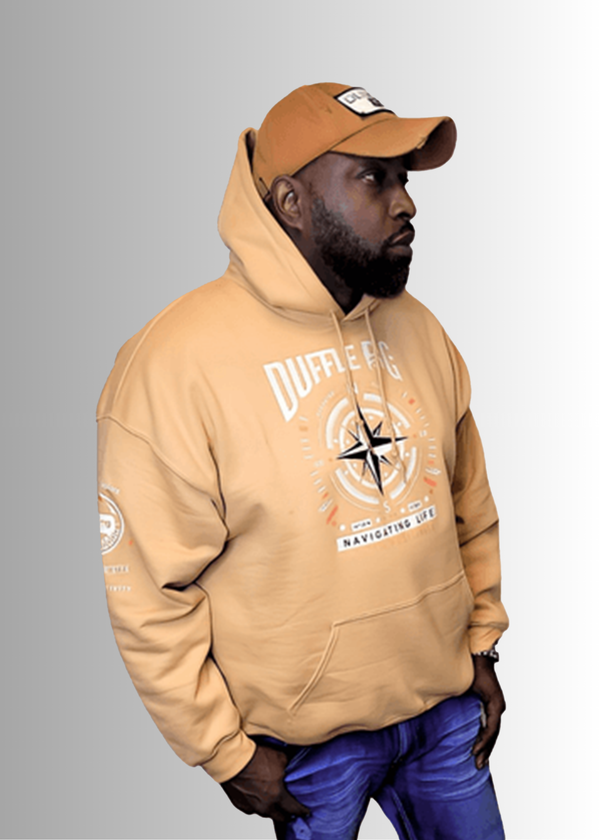 N.A.V Empowerment Hoodie by Duffle Bag with compass design, worn by a model.
#Tan